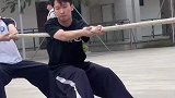 男生炫技迷惑对手，取得拔河比赛的胜利