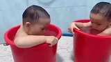 双胞胎在两个水桶对喷