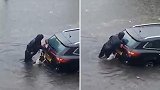 英国：一妇女带狗狗一起推被洪水淹没的汽车，营救两名被困女子