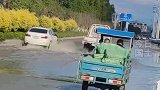 私家车无视三轮车主示意，路过水洼处不减速