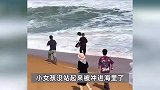 女孩海边玩耍被浪卷走，妈妈冲进海水救人被拍回，白衣小伙顶着大浪拼命救回