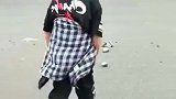 10岁男孩清理路中间碎砖块，妈妈帮着看过往车辆