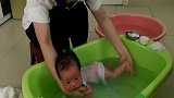 新生宝宝洗澡好萌啊！趴在月嫂手腕上小模样可爱极了