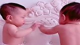 双胞胎兄弟光着膀子站床上，哥哥把奶嘴递给弟弟，真是太可爱了