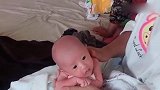 小宝宝趴在妈妈的手上，可爱的小眼神把人萌化了