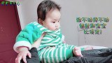 爸爸抱着宝宝一动不动，宝宝一会看看爸爸，一会瞅瞅小脚丫