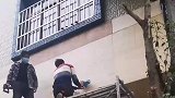 男子在墙上锯开一个洞，从里面掏出一包好东西