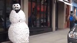 藏在雪人模型内捉弄路人，美女被吓得大叫起来