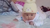 小宝宝趴在床上练习抬头，看宝宝这费劲的模样，简直可爱极了！