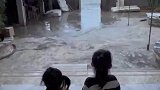 小女孩坐在家门口，观看门外的海浪