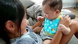 姐姐不停挤弄宝宝小胖脸，把娃气的哇哇大叫要咬人，大人都笑疯了