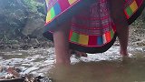 妹子在坑里抓鱼，不料野人悄悄观察着，趁妹子抓到鱼就出来抢