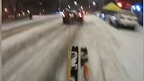 美国纽约：一大胆男子用绳子绑在汽车后，在曼哈顿大街上滑雪