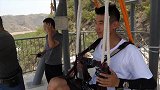 队里小哥替胖哥体验江上缆车 体验前准备工作细心检查