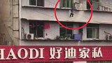 惊险！小孩悬吊四楼窗户防护栏不停挣扎 市民拉开棉被施救