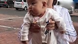 妈妈带小宝宝出门遛弯，宝宝东张西望的，感觉什么事情都好玩