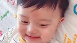 小男孩躺在床上，笑的好开心