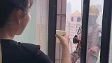 女子看到工人师傅高空修补外墙