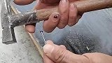 男子用铁锤敲铁钉，锤子一直砸在木板上
