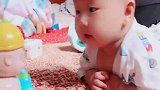 小宝宝看玩具的表情好逗，妈妈看到后忍不住笑了，实在是太可爱了