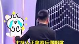 主持人拿着玩偶唱歌，女孩上台一个动作，主持人连忙把玩偶给她