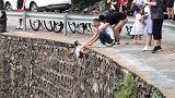 北京房山一幼童被家长挂在峭壁上照相 场面令人心惊