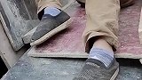男子用一根铁钉，钉住工友的鞋