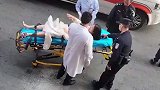 女子躺在担架上不断挣扎，双脚被捆无法动弹