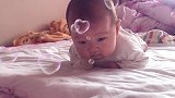 小宝宝躺在床上练习抬头，小家伙好萌呀，接下来的表情萌翻了！