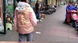 小女孩手持导盲杆，在路上行走屡次受阻