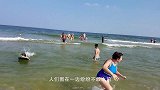 游客在岸上玩耍，巨大黑影却逐渐靠近，看清后慌忙逃窜！