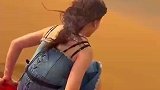 女生在沙漠玩滑沙，从坡顶滑到坡下