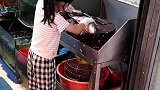 小女孩帮父母杀鱼动作麻利，拍摄者她懂得帮父母分担