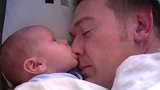 小宝宝和爸爸一起睡，突然饿了，张嘴就啃起了爸爸的鼻尖