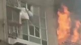大楼发生火灾，两女子攀爬防盗窗逃生