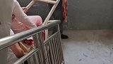 家人用自制担架将其抬上楼