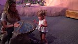 女儿趴在小恐龙上，妈妈在一旁守护，实在是有爱的一家！