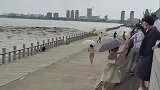钱塘江潮水再次冲上堤坝，观潮人群仓惶逃避