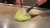 厨师将一片白菜，放在铁板上烧
