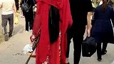 看到一个穿红色汉服的姑娘，也在看牡丹花，比牡丹花还漂亮
