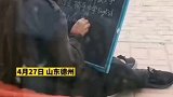 山东德州：流浪汉坐在街边黑板写字 中英文切换自如