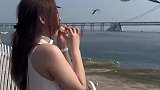 女孩用嘴叼面包喂海鸥，没想到被海鸥啄伤了嘴部