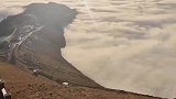 网友拍摄到云海漫过山岭，好似潮涨潮落