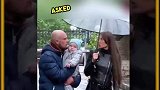 男子抱着孩子向这位女士索要雨伞时