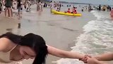 女子和闺蜜在海边玩耍，被闺蜜硬生生拽到海里