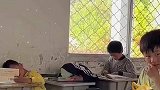 小朋友毛巾蒙头趴桌子，老师发现后尴尬的露出了笑容