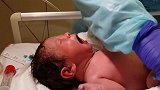 产科护士给新生宝宝清理，宝宝张着嘴巴哭个不停，看着真心疼啊
