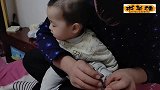 小宝宝刚睡醒坐在爸爸怀里修指甲，宝宝吓的一动不动，可爱