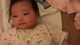 小宝宝看着妈妈，露出了开心的笑容，超可爱