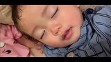 半梦半醒的小宝宝边睡边笑，小模样太可爱了！
